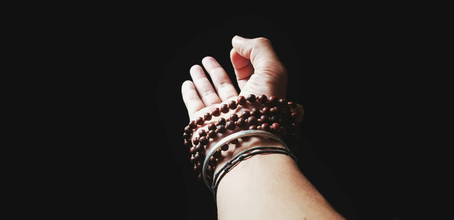 a close up view of a persons hand with many beads on it