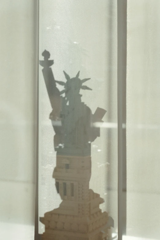 a statue sitting inside of a glass case next to a window