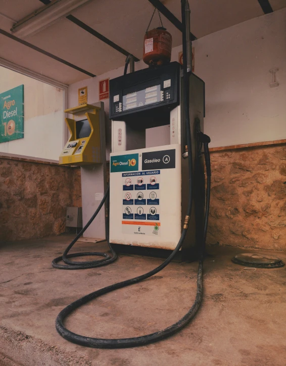 a fuel dispenser with nozzles at the top sits in the middle of a garage
