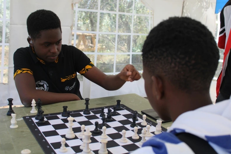 a man and boy sitting at a chess board