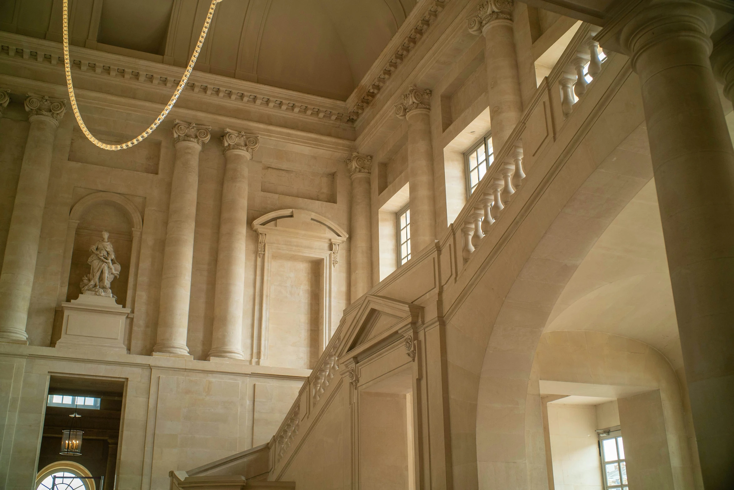 a staircase leading to two story white marble building