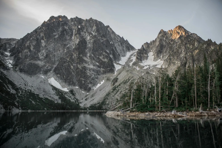 mountains are reflected in water surrounded by trees