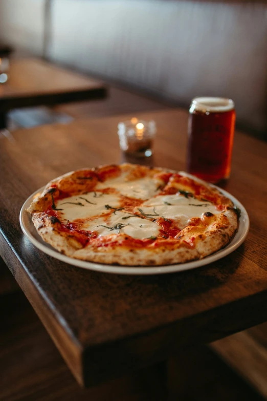 a small pizza sitting on top of a table next to a drink