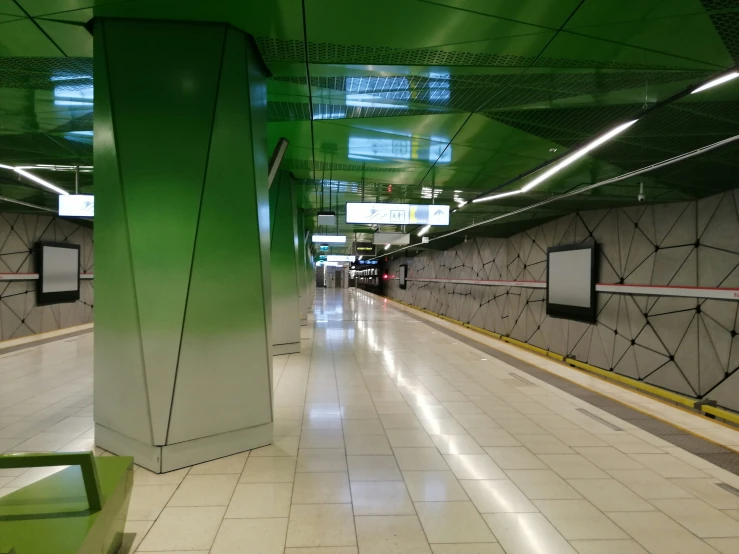 a tunnel with three green pillars on the side