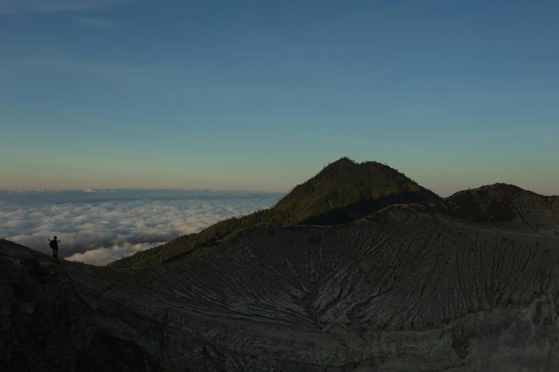 three people standing at the top of a mountain