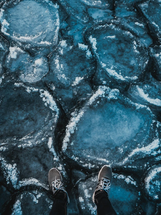 person standing on icy water with their feet propped up