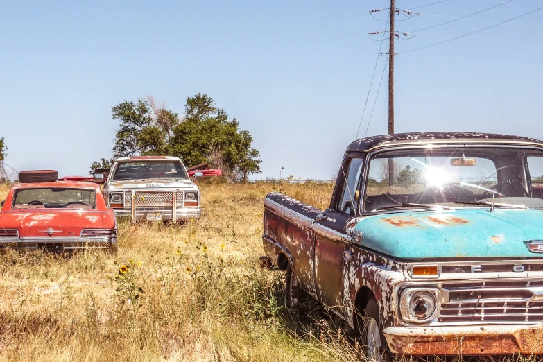 there are four trucks that are parked in a field