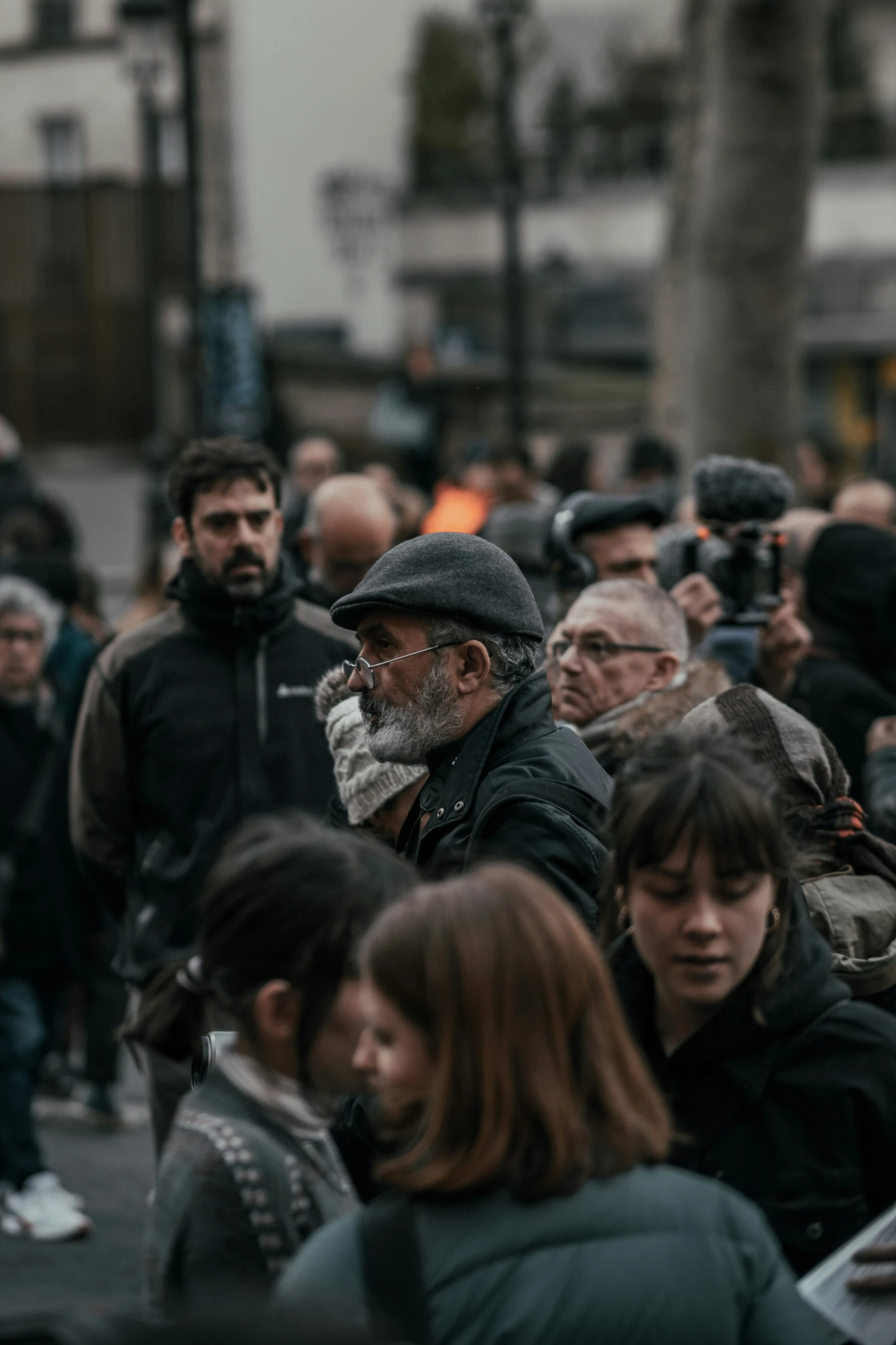 large crowd of people walking down the street with cameras