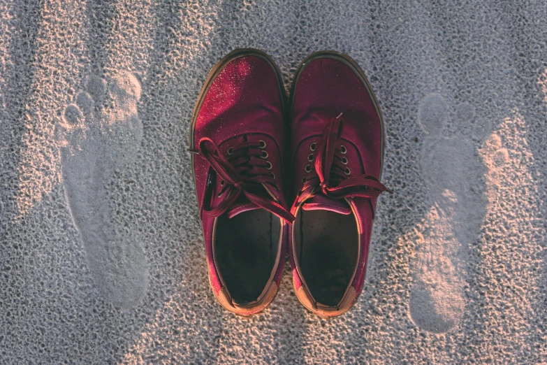 two red shoes on the floor, one is pink