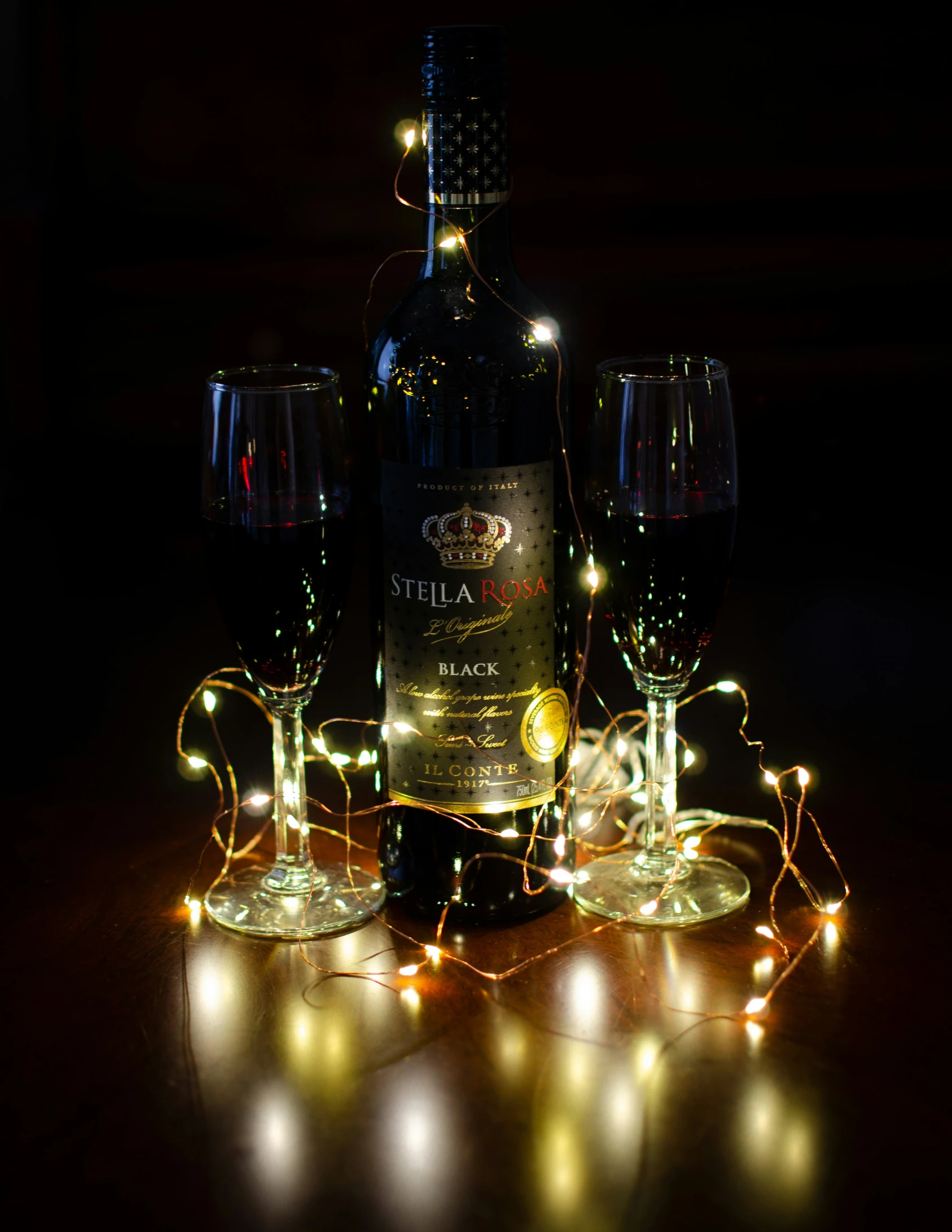 two wine glasses with some lighted lights around them