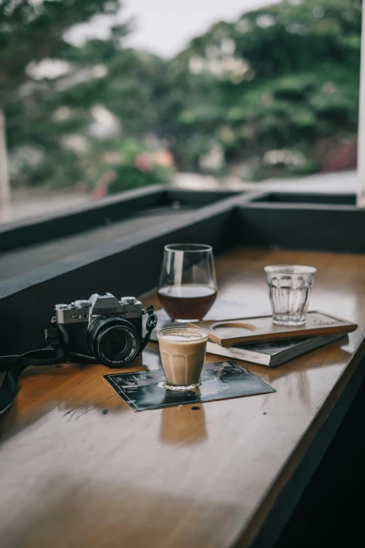 a wooden table holding a drink and a book