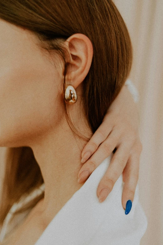 a close up of a woman wearing a ring and earrings