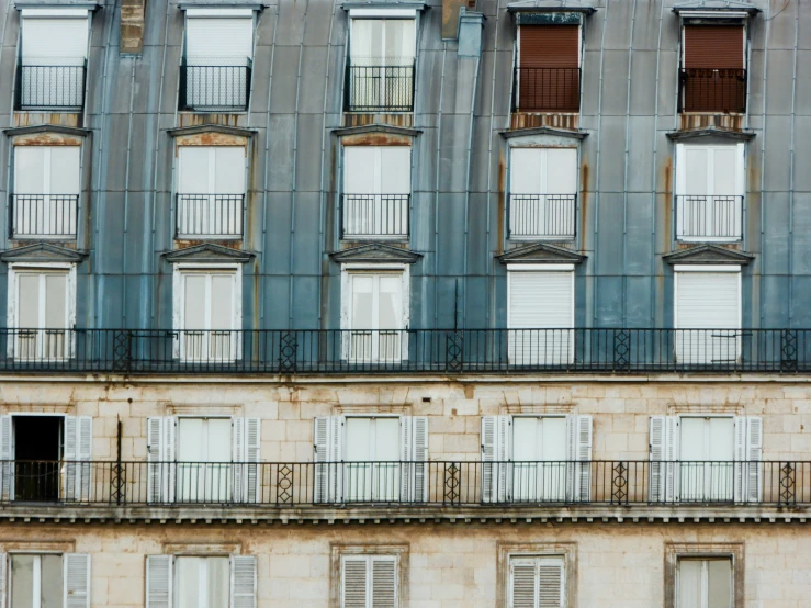 a building with open windows is standing next to a curb