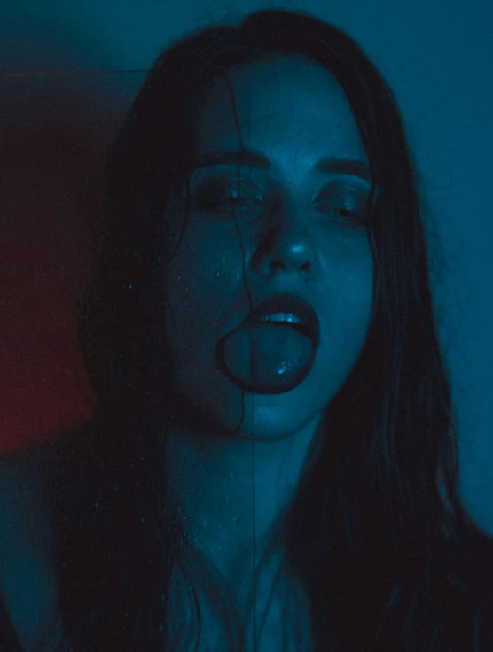 a woman with long dark hair and blue lights has an open mouth