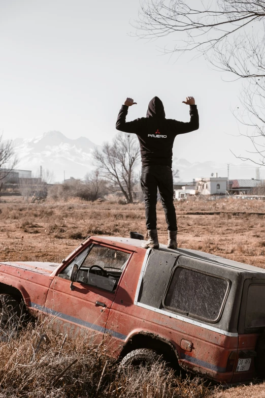 a person standing on top of an old car