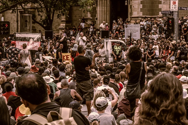 a large group of people stand in the street