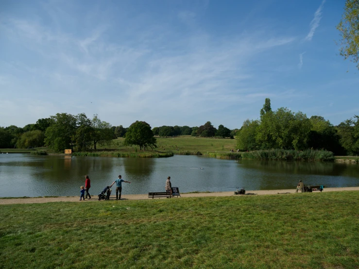 the people are by the water and near the benches