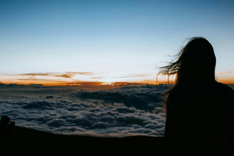a person standing above some clouds with a camera