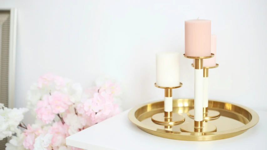 a white and gold candle holder on a table