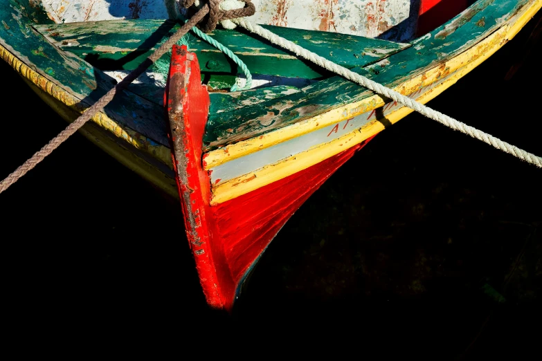 a red and blue boat tied to ropes