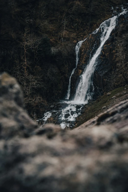 there is a waterfall in the distance from the rocks