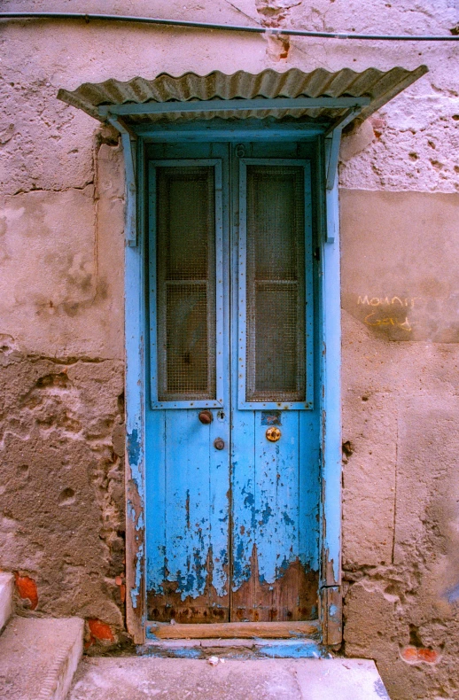 a door sitting on the side of a wall next to a sidewalk