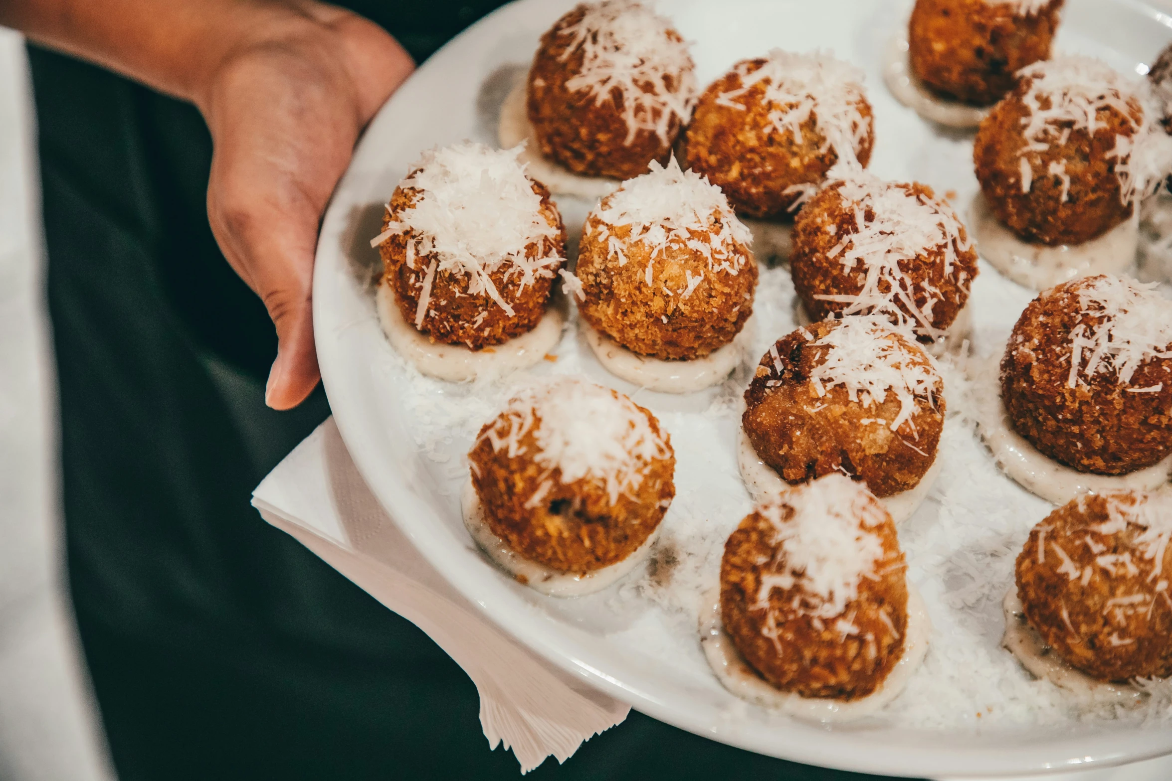 some desserts sit on a white plate and someone is holding one