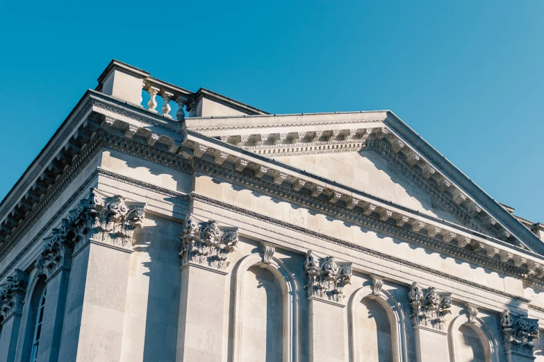 a large building with many tall columns under a blue sky