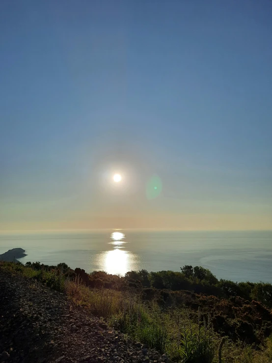 a bench is on a rocky hill near the ocean