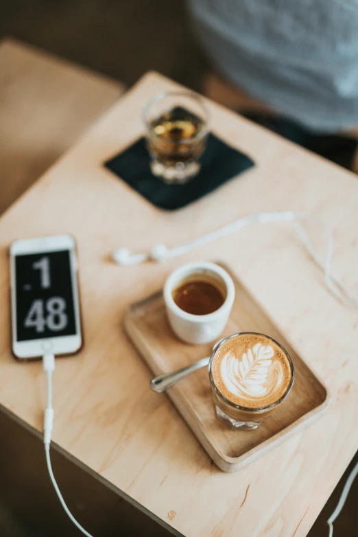 someone is enjoying a cup of coffee and their cell phone