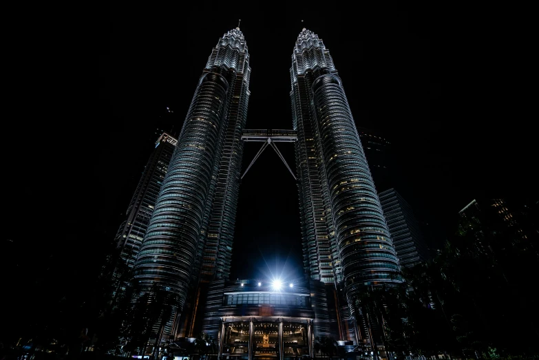 two tall buildings towering into the sky in front of people