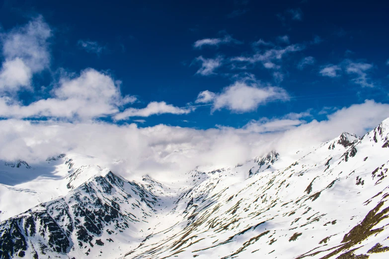 a group of skiers skiing on a very tall snowy mountain