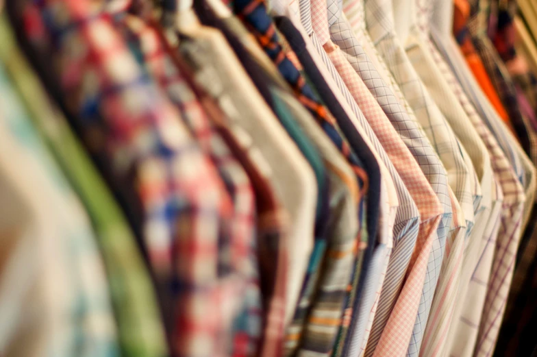 the man's shirts and ties hang in rows