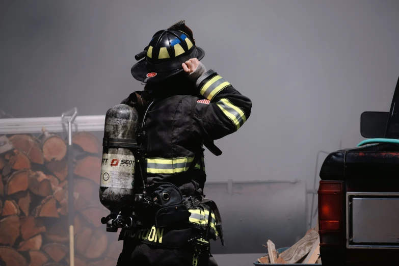 a man wearing a fire fighter's uniform and breathing in a smoke