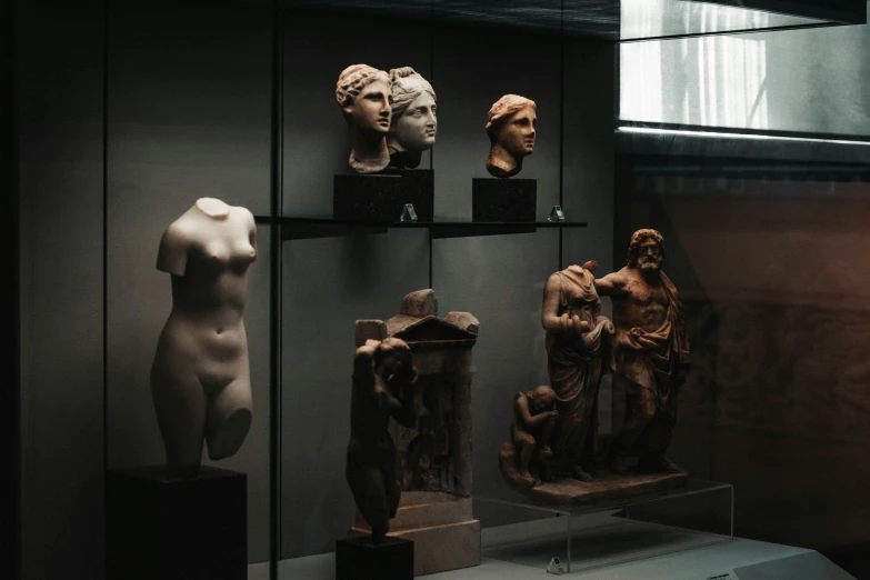 several sculptures are displayed in glass cases together