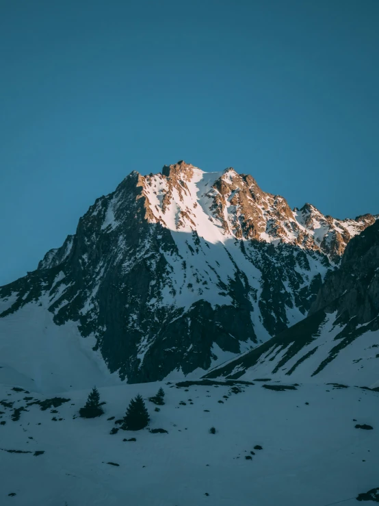 the top of a mountain is illuminated by the setting sun