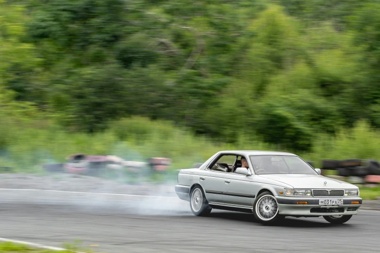 a white car emitting out some smoke on the road