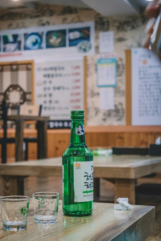 a table is covered with green glassware and an empty bottle