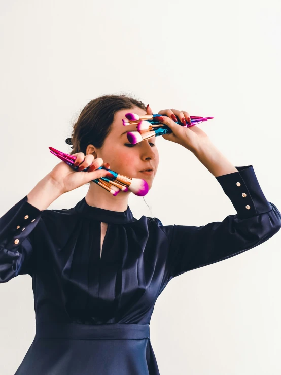 a woman holding many crayon pencils over her head