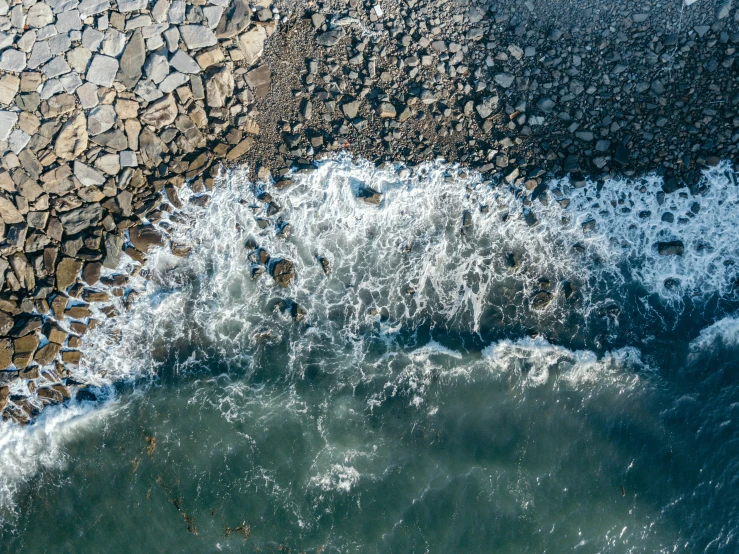 an aerial view of some very pretty rocks near the ocean