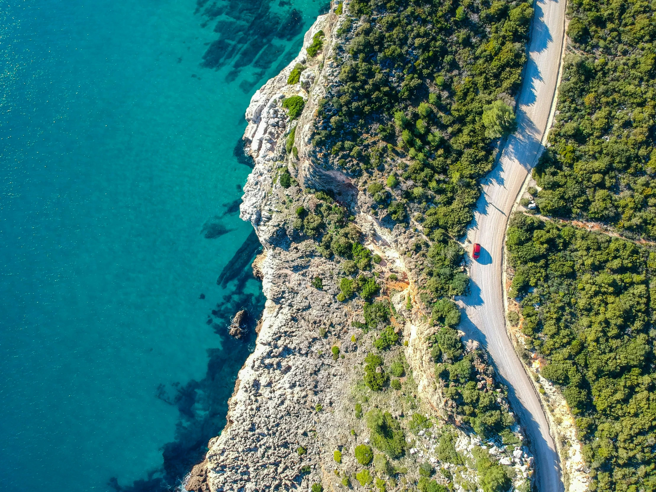 an overhead view of a long and winding trail by water