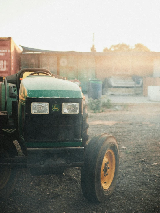 a black tractor is parked in a gravel field