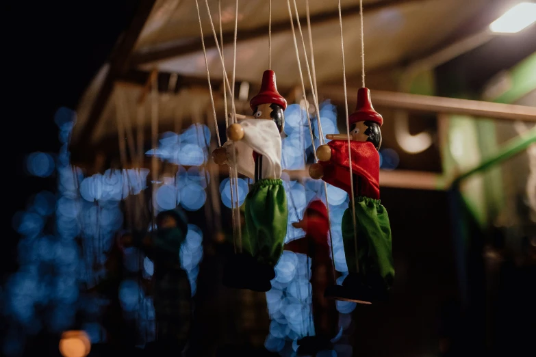 two red - headed toy gnomes are hanging from strings