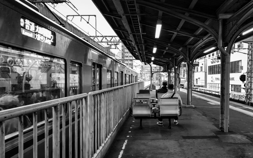 a train station with people sitting and waiting