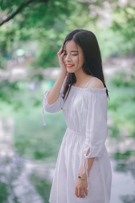 a beautiful young woman standing by some water