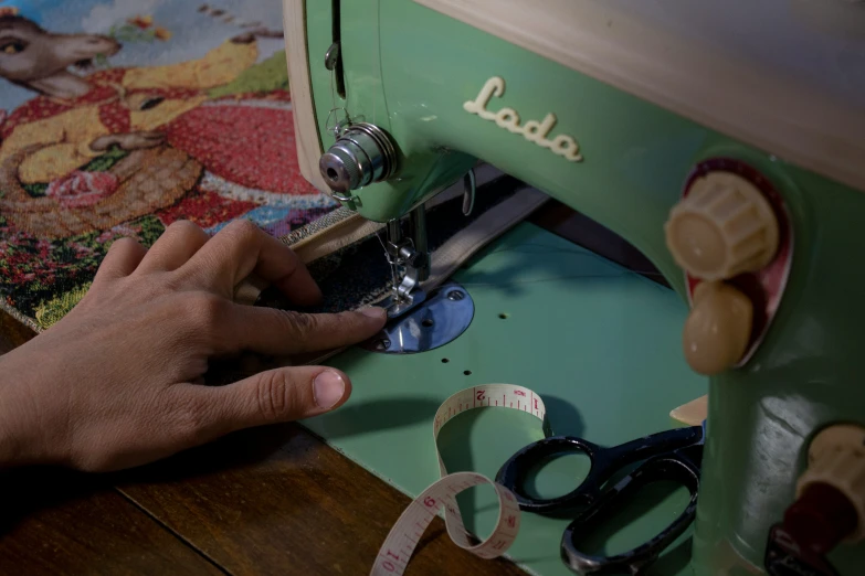 someone working on the sewing machine with scissors and tape