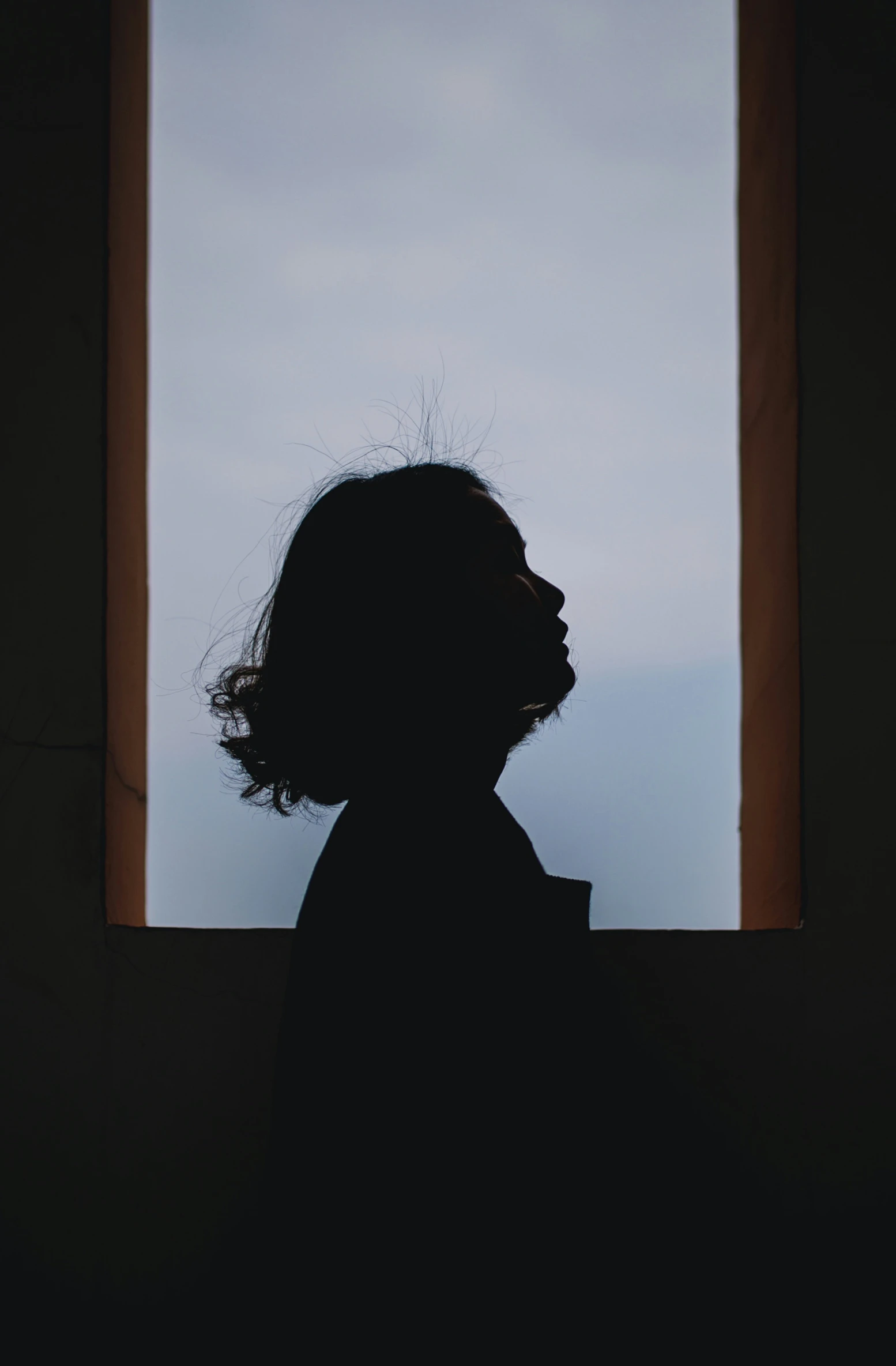 a person is looking out the window at a cloud in the sky