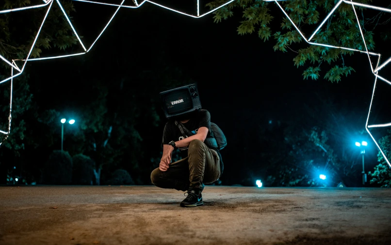 a person kneeling on the ground with an object over their head