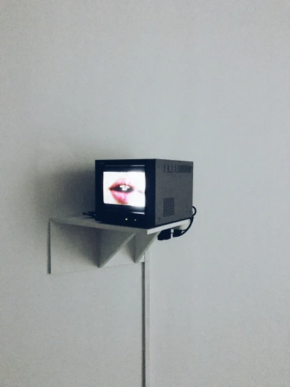 an old television on a stick with one eye projected onto the screen