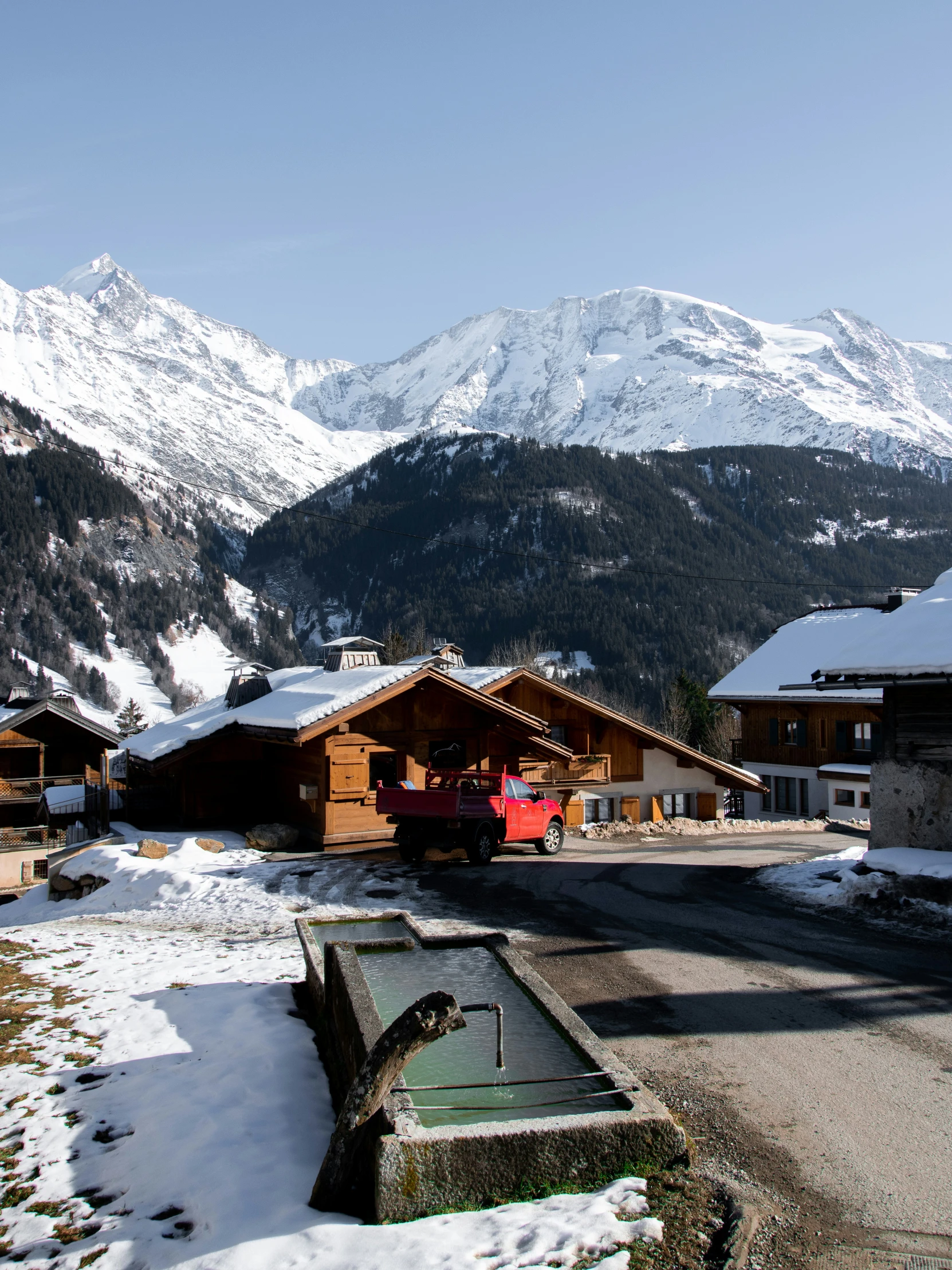 the mountains behind the ski lodge are very tall